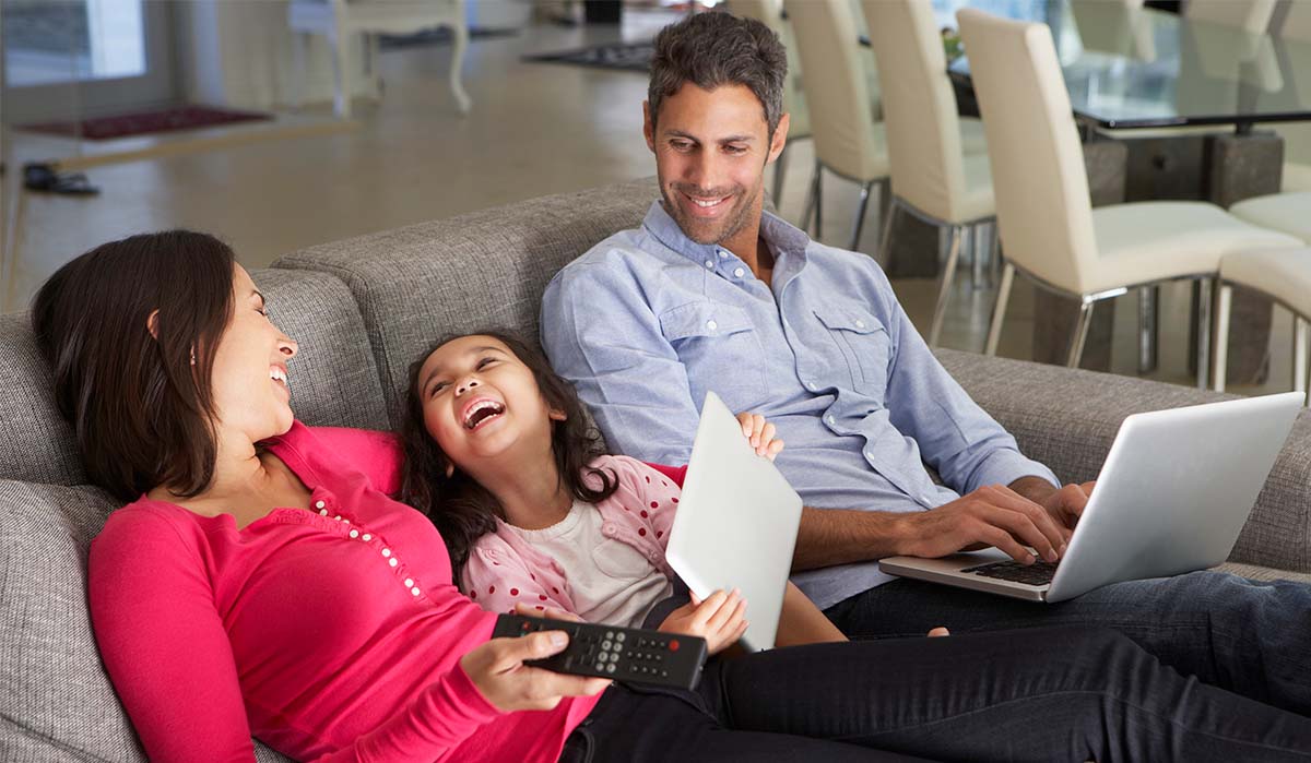 Familia hispana disfrutando de la vida con múltiples dispositivos conectados
