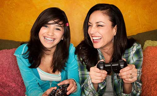 Mother and daughter having fun while gaming 